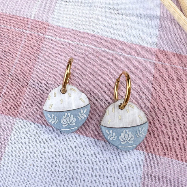 Pair of earrings on a checkered fabric background